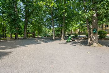 A park with trees and a green bench